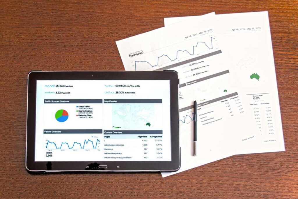 marketing de influência - tablet e papéis com gráficos e dados sobre a mesa