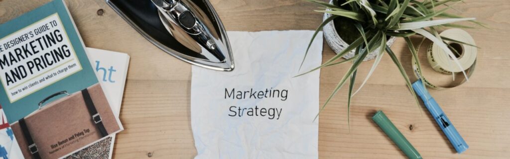 Ferro passando sobre papel amassado com a escrita: marketing strategy
